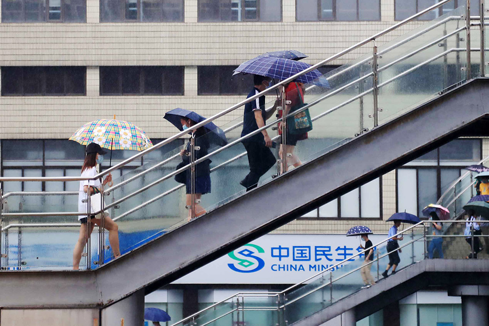 2022年9月5日，上海，受台风“轩岚诺”影响，早高峰时，市民撑伞出行。IC 图